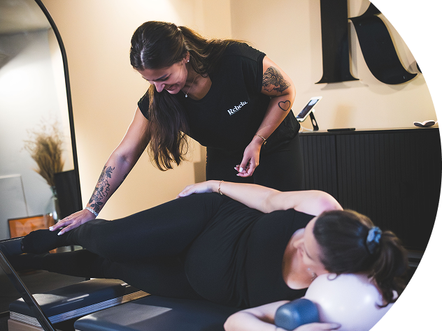 Femme enceinte pratiquant le Pilates Reformer avec coach certifié au studio Rebela Toulouse, exercice adapté prénatal