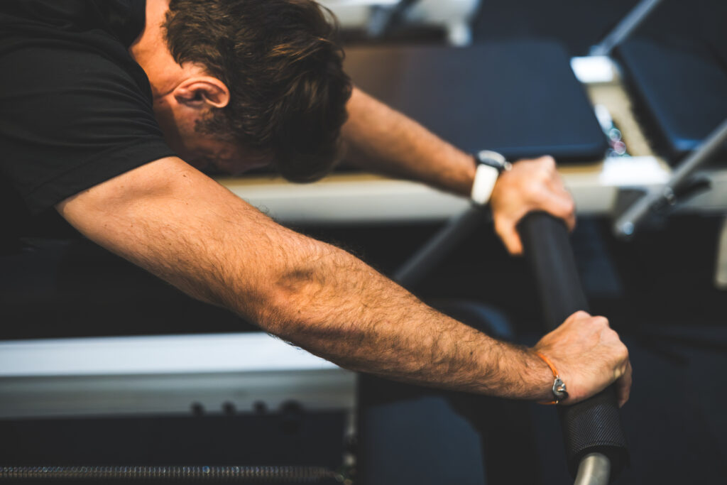 homme pendant un cour de pilates reformer